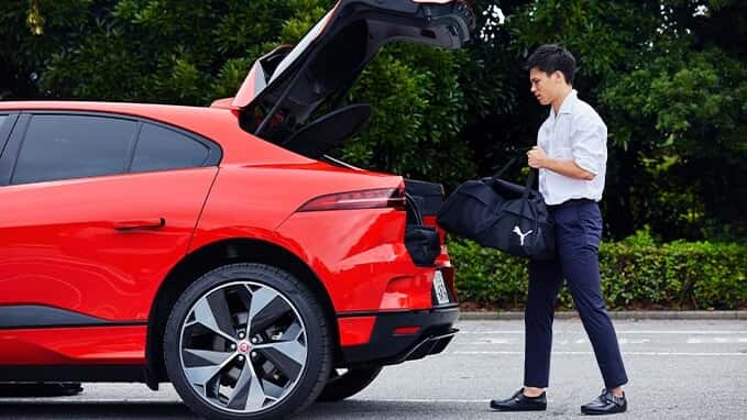 Ryo Miyaichi is putting his luggages in a Jaguar I-Pace
